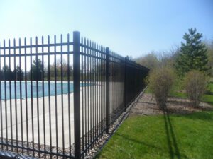 a tall black metal fence built around a pool