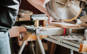 a person cutting wood with a miter saw