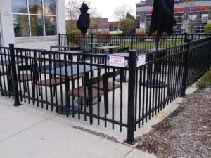 black ornamental fencing surrounding picnic tables