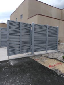 a gray privacy fence with the front gate open