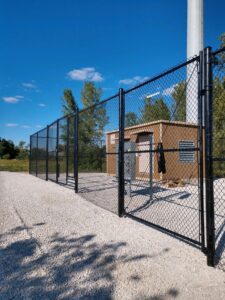 a large black fence surrounding an important maintenance building