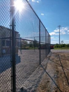side shot of a tall black chainlink fence
