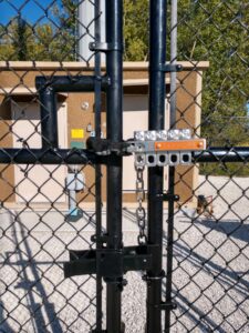a lock on a black chainlink fence gate
