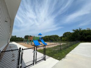 a black chainlink fence around a playground with a gate