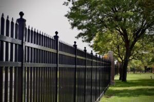 black decorative fence built between stone decorative stone columns