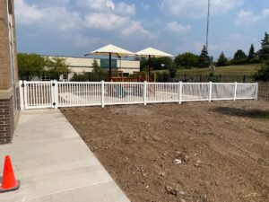 a white decorative pvc fence around a playground