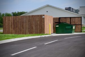a wooden privacy fence built around a trash receptacle