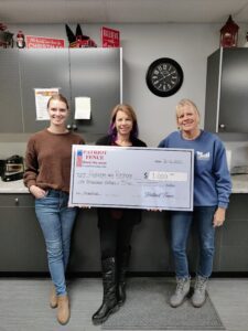a large check for 1000 dollars being held by a patriot fence customer