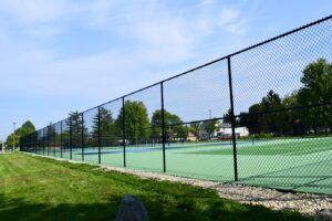 a black chainlink fence around tennis courts