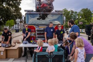 children and family talking to firefighters