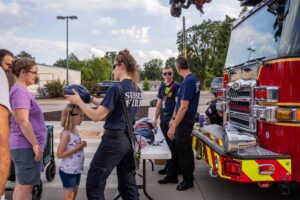 side of of firefighters talking with children