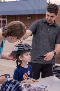 parents fitting bike helmet on child